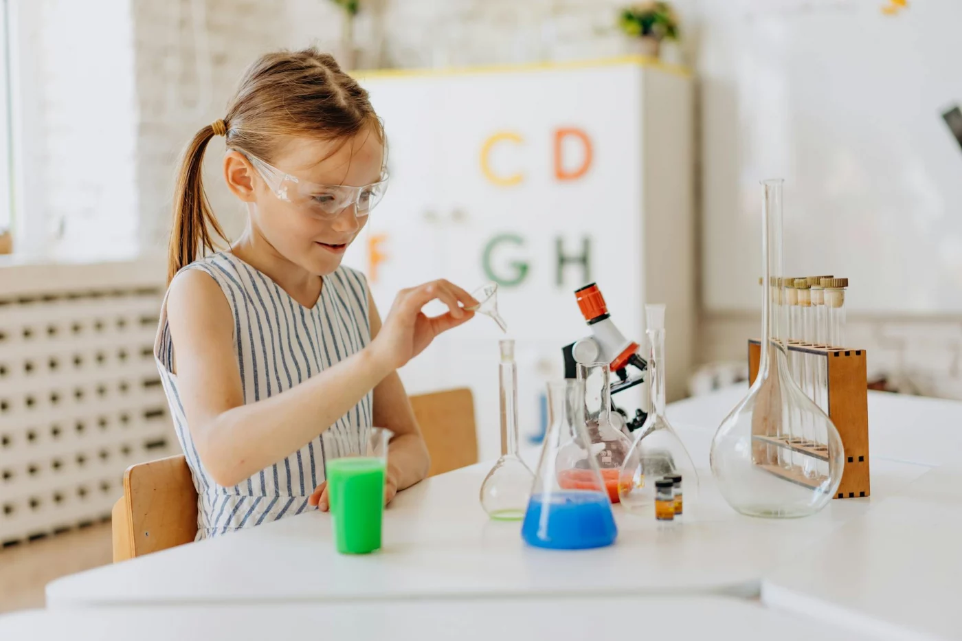 Child observing a tabletop science activity with lab equipment