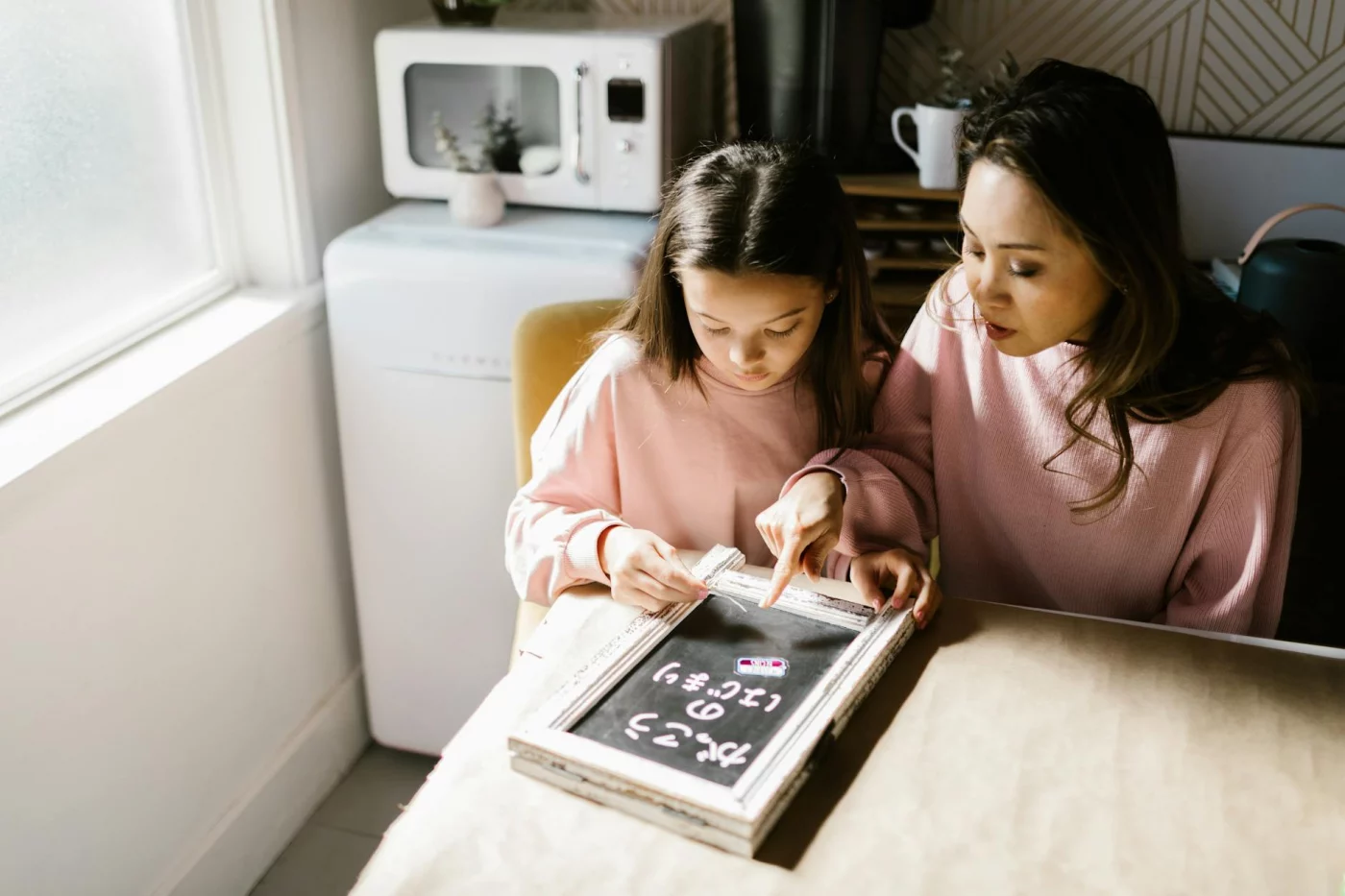 Mother and daughter study together at home, showing how parents can help with homework through a simple routine