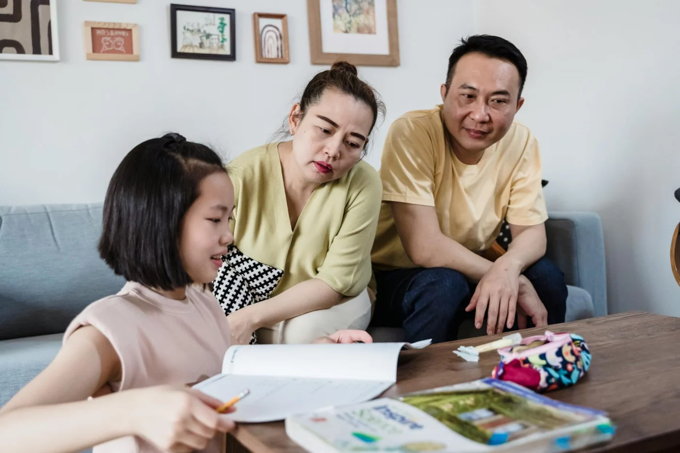 Parents assisting their daughter in a cozy living room, showing how parents can help with homework without taking over