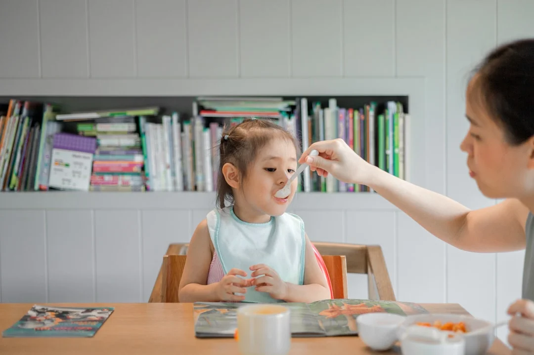 Woman holding a white plastic spoon while discussing simple meals for fussy eaters in an FAQ section