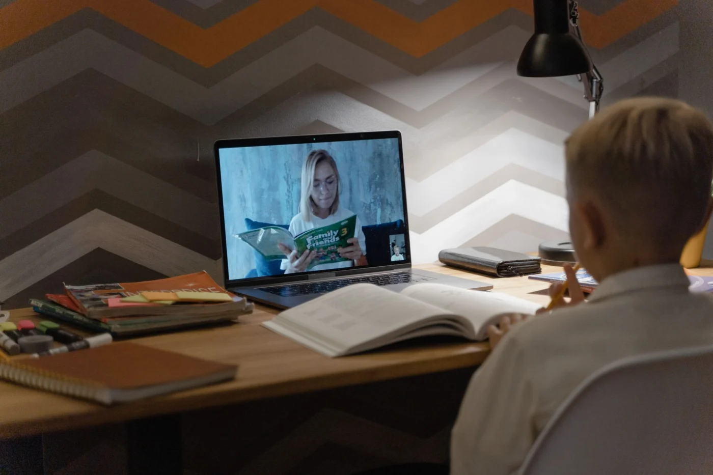Child in an online lesson while parents compare homeschool curriculum options