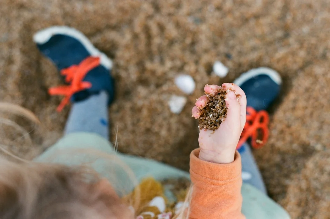 Girl holding sand in her hands during sensory activities for 3-5 year olds