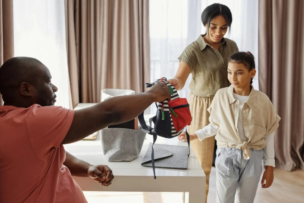 Family helping a young child get ready for school indoors