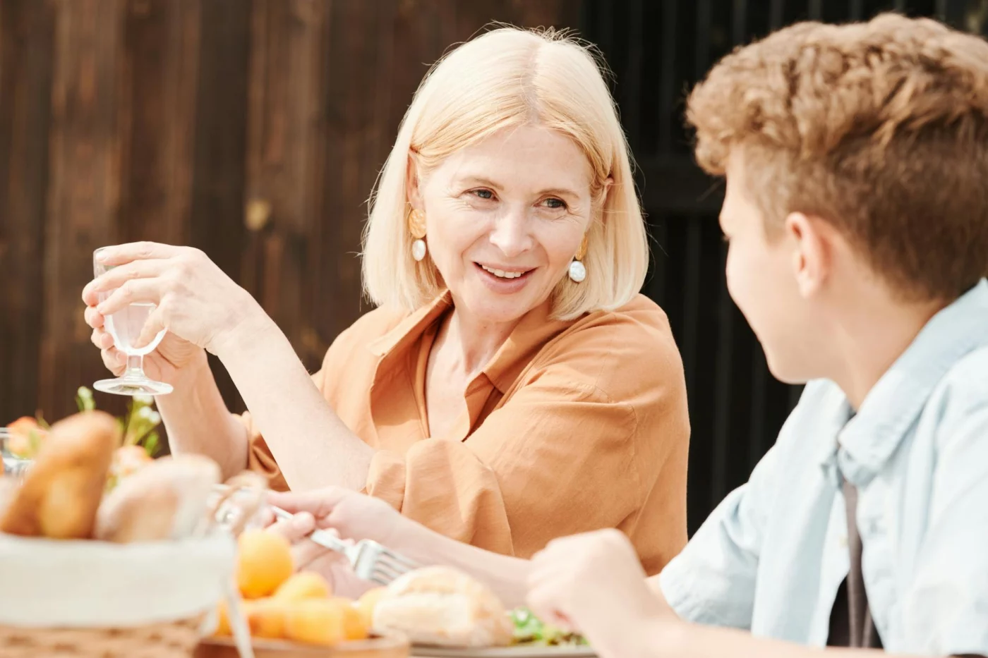 Mother and son share a joyful outdoor lunch while discussing does authoritative parenting work in family life